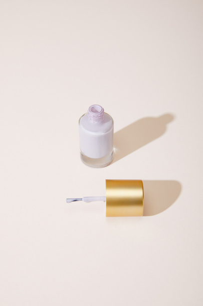 High angle view of opened bottle of nail polish on white background - Fotó, kép