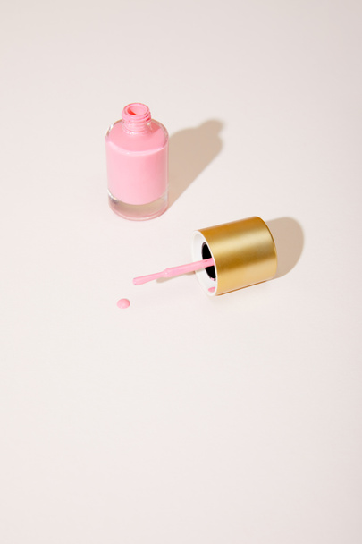 High angle view of opened bottle of pink nail polish on white background - 写真・画像