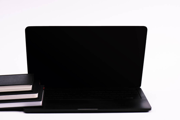 notebooks near black laptop with blank screen isolated on white  - Fotó, kép