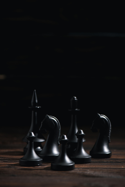 chess figures on textured surface isolated on black  - Φωτογραφία, εικόνα