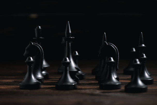 enfoque selectivo de figuras de ajedrez en superficie texturizada aislada en negro
  - Foto, Imagen