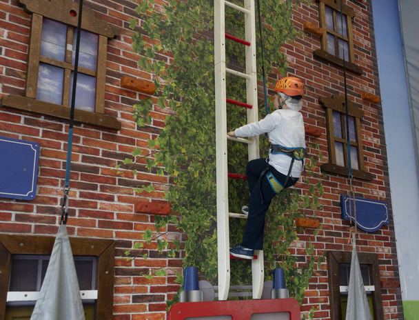 jongen op het klimmen op de muur in de sportschool beoefenen van extreme sport - Foto, afbeelding