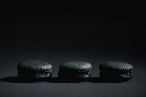 prepared dark macarons on black with copy space  - Fotó, kép