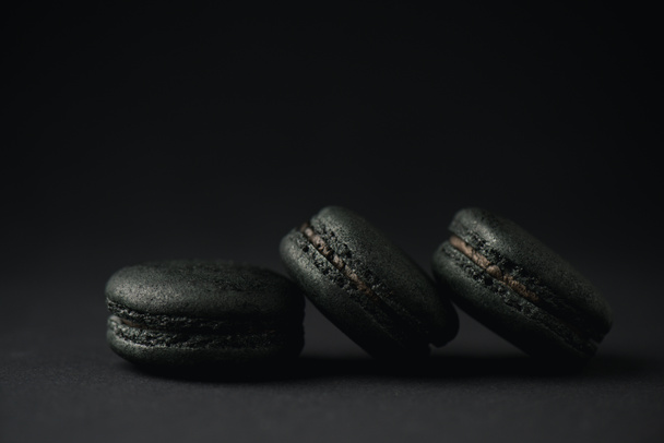 dark and tasty macarons on black with copy space  - Foto, imagen