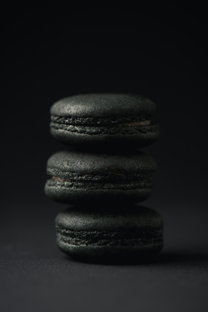 sweet and dark macarons on black with copy space  - Foto, Bild