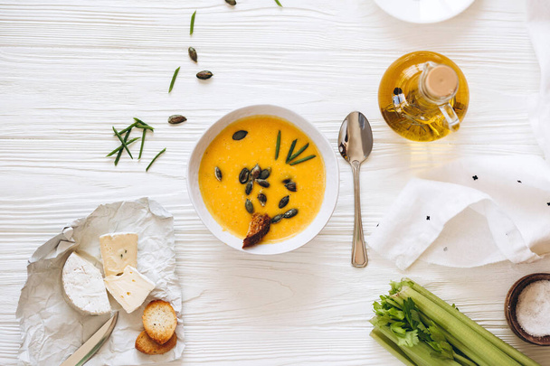 Homemade pumpkin soup with seeds, cheese and croutons on white table - Foto, Bild