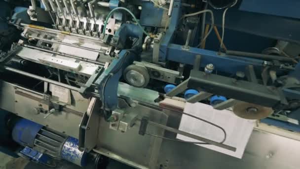 Conveyor mechanism is binding printed paper - Footage, Video