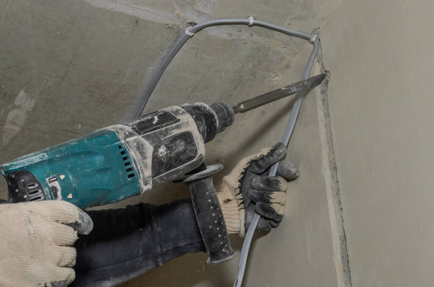 Worker breaks a concrete wall with a perforator chisel - Foto, Imagem