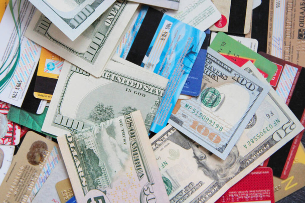 Hundred dollar notes and credit cards. Heap of credit cards and dollars. Cash and non-cash money. Plastic cards and dollars. Money in cash and credit cards - Photo, Image