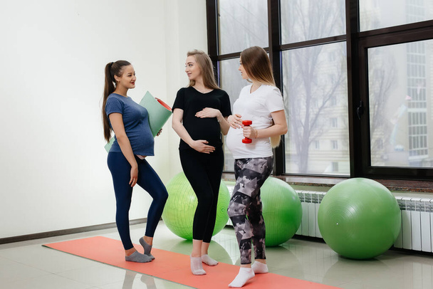 Bir grup hamile kız yoga yapıyor ve içeride sosyalleşiyor. Sağlıklı yaşam tarzı - Fotoğraf, Görsel