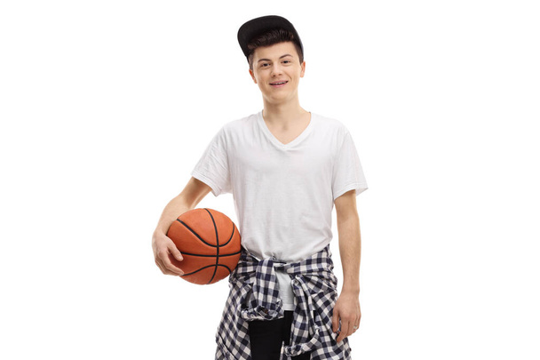 Cool teenager guy posing with a basketball isolated on white background - 写真・画像