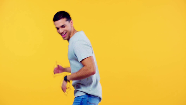 fröhlicher Mann im grauen T-Shirt tanzt vereinzelt auf gelb - Filmmaterial, Video