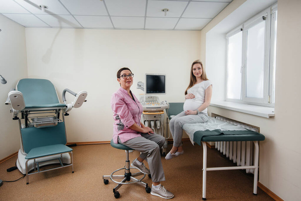 Uma menina grávida é aconselhada por um médico após um ultra-som na clínica. Exame médico - Foto, Imagem