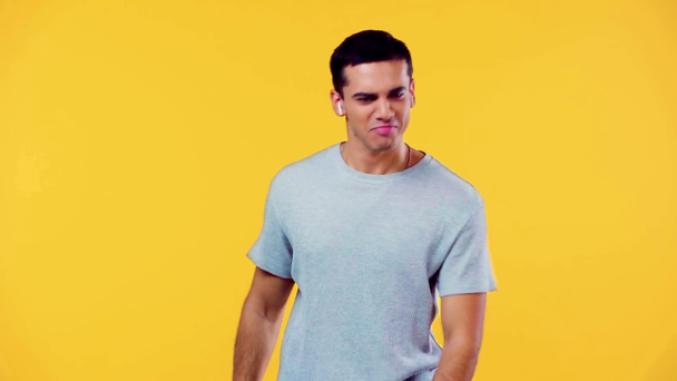 hombre feliz en auriculares inalámbricos bailando aislado en amarillo
 - Imágenes, Vídeo