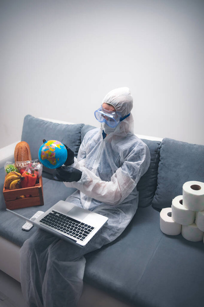 Quarantine and isolation during the virus outbreak - groceries and food in stock, working from home over the internet, holding globe map. - Photo, Image