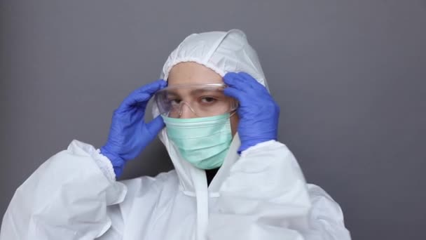 Close up of a woman in protective costume putting on glasses and mask - Video