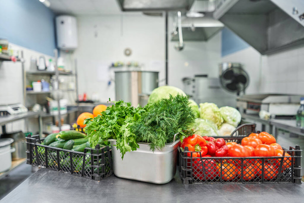 Свежие красочные овощи и фрукты на кухне на серебряном стальном столе. Рабочая поверхность и кухонное оборудование на профессиональной кухне
. - Фото, изображение