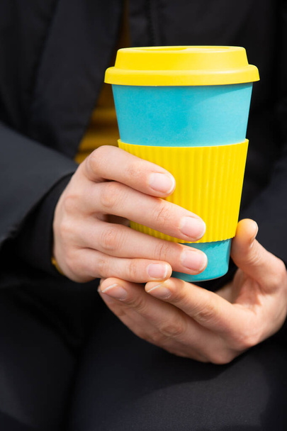 女性の手は再利用可能なコーヒーマグカップを保持。再利用可能な旅行マグカップでコーヒーを飲みましょう。廃棄物ゼロ。持続可能なライフスタイルコンセプト. - 写真・画像