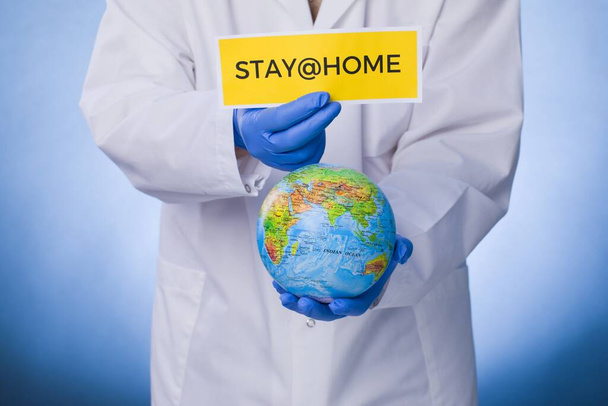 Coronavirus Quarantine, warning sign with the text stay at home in doctor hands in white coat, gloves, face medical mask. Quarantine coronavirus Pandemic. Coronavirus outbreak. - Foto, Bild