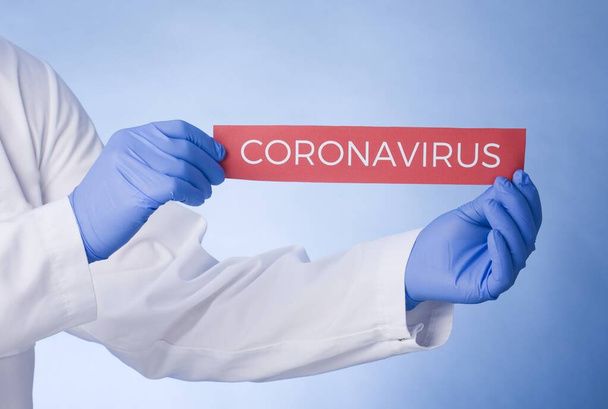 Coronavirus Quarantine, warning sign with the text stay at home in doctor hands in white coat, gloves, face medical mask. Quarantine coronavirus Pandemic. Coronavirus outbreak. - Foto, afbeelding