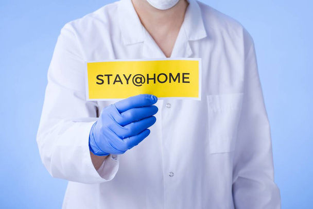 Coronavirus Quarantine, warning sign with the text stay at home in doctor hands in white coat, gloves, face medical mask. Quarantine coronavirus Pandemic. Coronavirus outbreak. - Foto, Imagem
