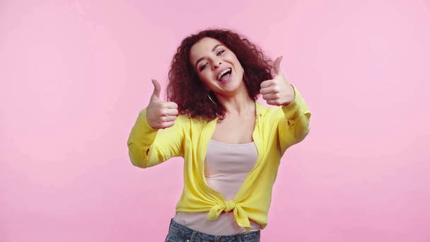 opgewonden, gelukkig meisje tonen duimen omhoog en glimlachen op camera geïsoleerd op roze - Video