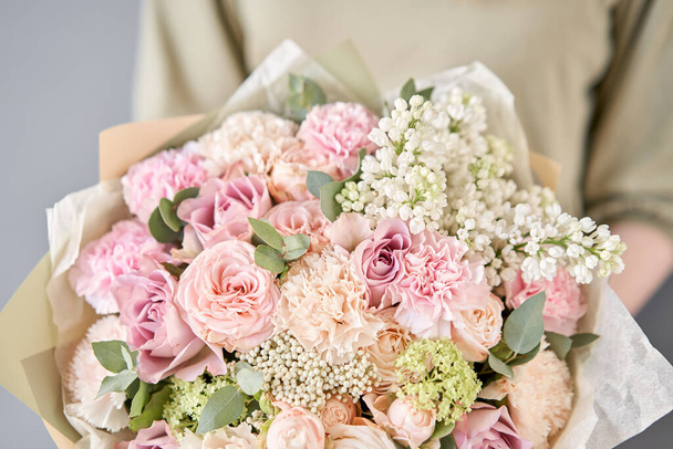 Small flower shop and Flowers delivery. Beautiful bouquet of mixed flowers in woman hands. Work of the florist at a flower shop. Delivery fresh cut flower. - Photo, image