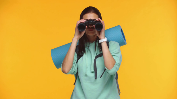 Gelukkig reiziger kijken naar verrekijker en blazen lucht kus geïsoleerd op geel - Video