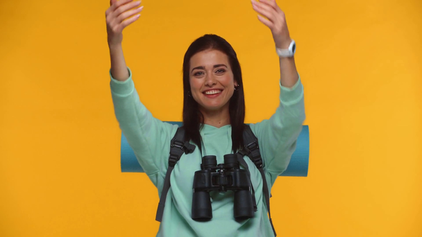Усміхнений мандрівник викликає когось і вказує рукою ізольовано на жовтому
 - Кадри, відео