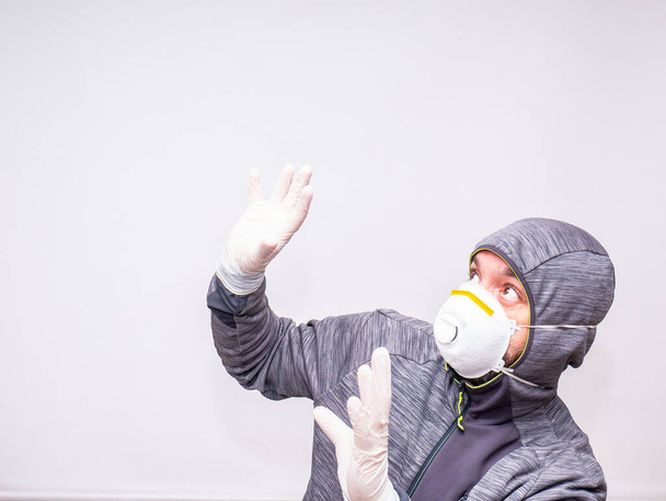 Man with mask and gloves looks surprised up - Photo, Image