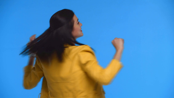 Весела дівчина танцює і крутиться на камеру ізольовано на синьому
 - Кадри, відео