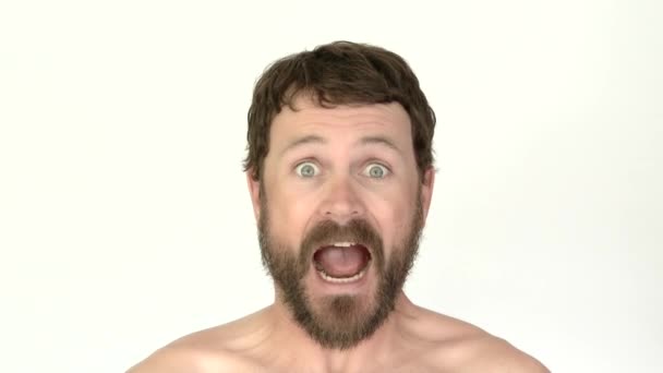 Modello rilasciato uomo in studio con barba con varie reazioni sorprese, sorridente e ammiccante
. - Filmati, video