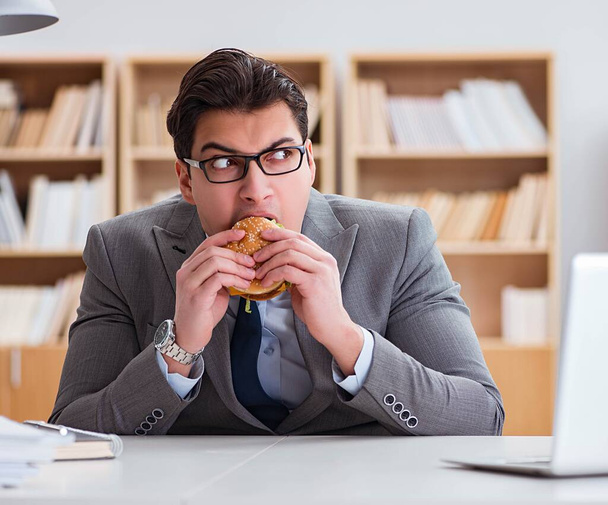 Голодные веселые бизнесмены едят сэндвичи с нездоровой едой - Фото, изображение