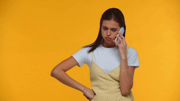 Mujer enojada peleando y lanzando teléfono inteligente aislado en amarillo
 - Metraje, vídeo