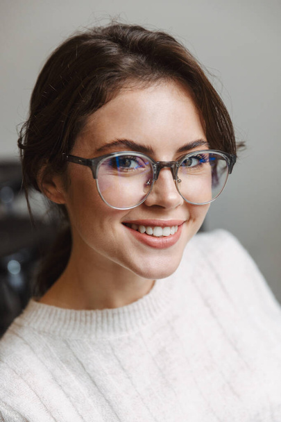 Image of young beautiful caucasian woman wearing eyeglasses smiling and looking at camera indoors - Foto, Bild
