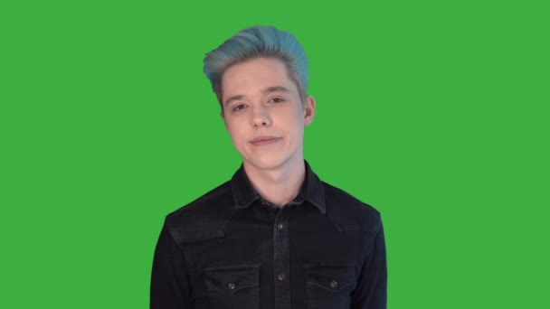 Mladý muž se usmívá na zelenou obrazovku kamery. Gay s barevnými vlasy. Modré vlasy - Záběry, video