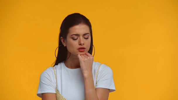 Pensive girl having idea isolated on yellow - Footage, Video