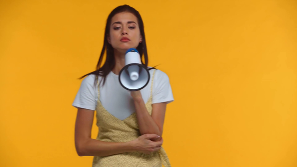 Boos meisje praten op luidspreker en wijzen met de vinger geïsoleerd op geel - Video