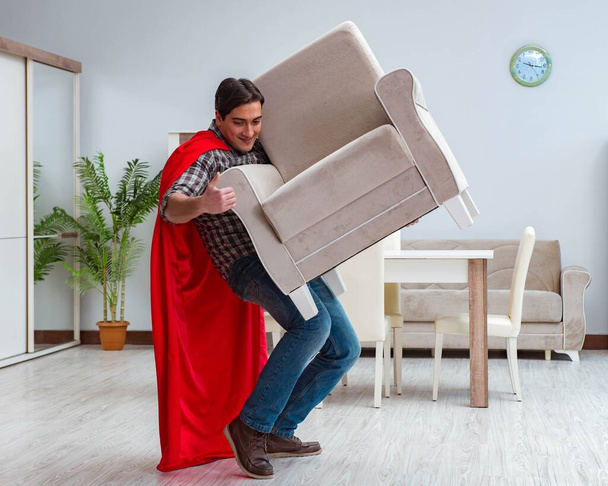 Super hero moving furniture at home - Photo, Image