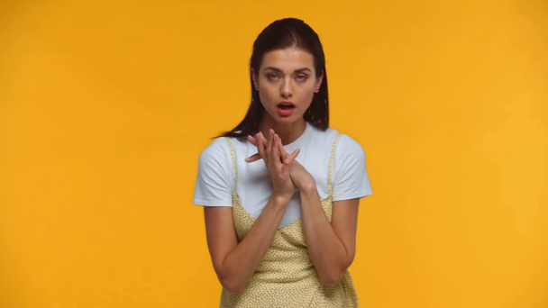 Όμορφη κοπέλα που μιλάει και κάνει χειρονομίες στην κάμερα απομονωμένη στο κίτρινο - Πλάνα, βίντεο