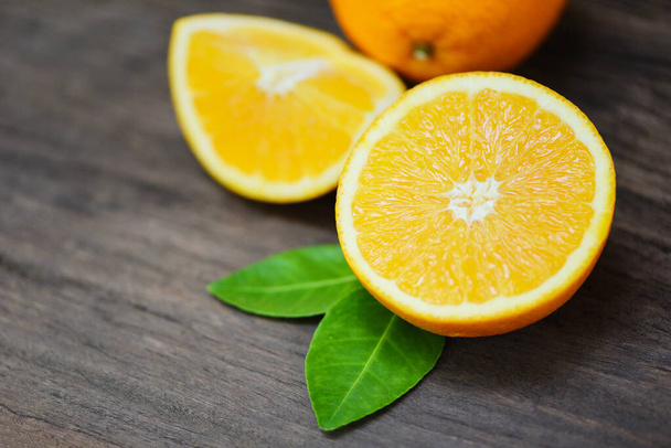 Orange fruit on wooden background / Fresh orange slice half and orange leaf healthy fruits harvest concept - 写真・画像