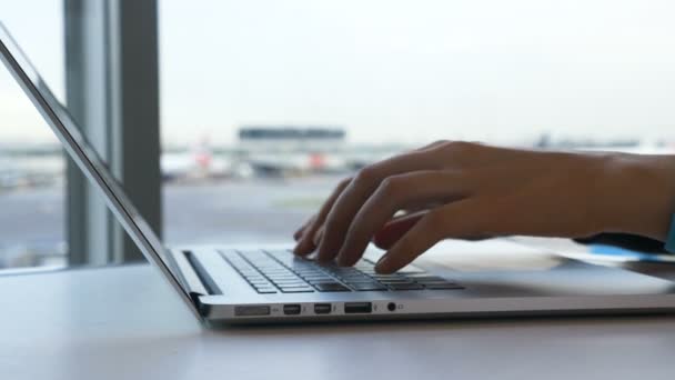 空港のカフェでノートパソコンのキーボードの女性のタイプを閉じるビュー - 映像、動画