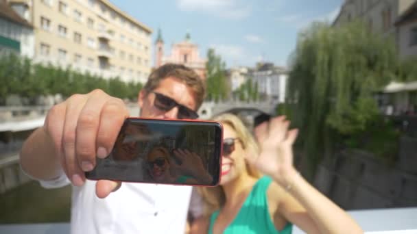 SLOW MOTION: Vrolijke man houdt zijn mobiele telefoon te nemen van een selfie met vriendin. - Video