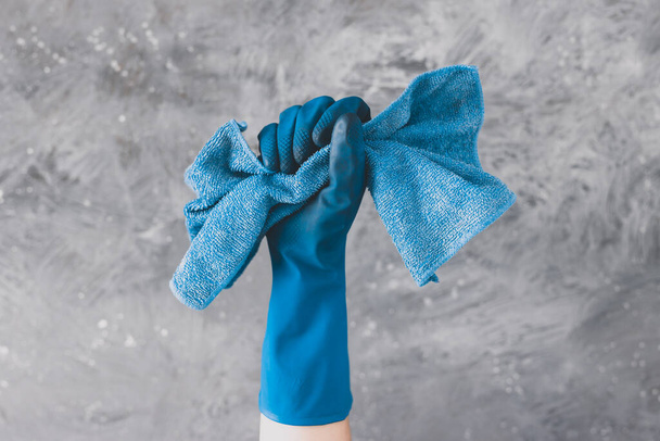 cleaning and disinfecting surfaces to fight bacteria and viruses, hand with blue cleaning glove holding microfiber cloth  - 写真・画像