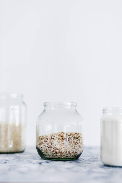 healthy non-perishable food ingredients for vegan pantry, glass jars with oats flour and rice  - Fotoğraf, Görsel