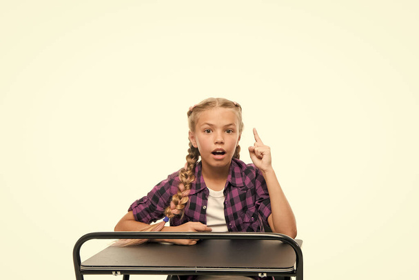Homework idea. Little girl keeping finger raised isolated on white. Adorable small child reciting homework in class. Doing homework assignment. Homework supervision - Photo, image