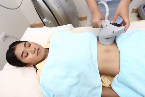 脂肪患者としてのアジアの女性の治療と病院の診療所で腹の胃の医療美容機器の問題を調べる - 写真・画像