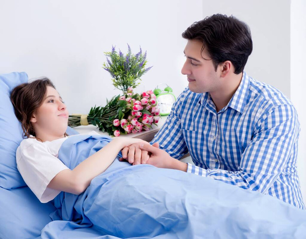 Caring loving husband visiting pregnant wife in hospital - Фото, изображение