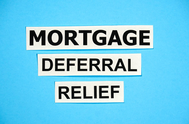 Mortgage deferral relief writing on blue background. Many banks worldwide announced mortgage and payments relief because of coronavirus covid 19 for people who cannot make their payments in time. - Photo, Image