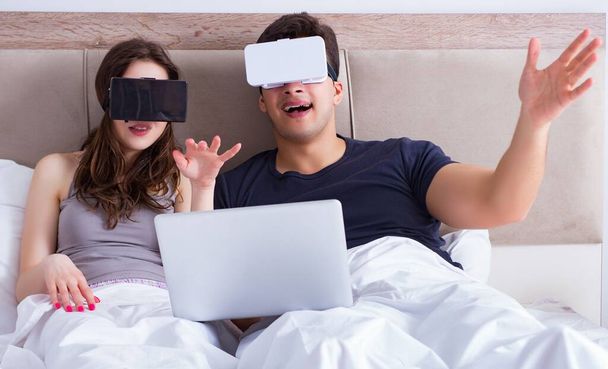 A feleség és a férj virtuális valóság szemüveg az ágyban - Fotó, kép